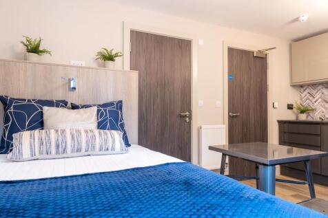 A modern single bedroom featuring a comfortable...