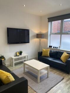 Bright, modern living room with two black leath...