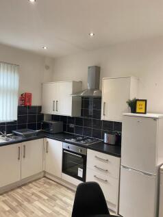 Modern fitted kitchen with white cabinets, blac...