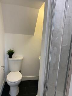 Compact, modern bathroom with a tiled shower en...