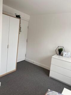 Bright, simply styled bedroom corner with neutr...