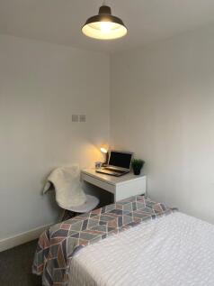 Bright, simply furnished bedroom with a neatly ...