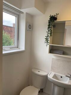 Bright, tidy bathroom with a white toilet and p...