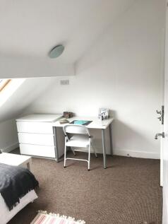 Bright, neatly furnished attic bedroom with a w...