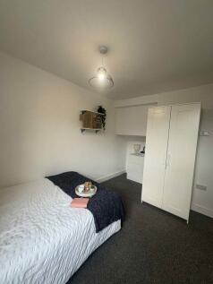 Bright, simply styled bedroom with a neatly mad...