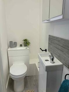 Bright, modern bathroom with a compact white ba...