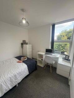 Bright, neatly furnished single bedroom with a ...