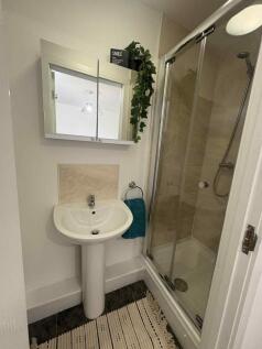 Bright, modern bathroom featuring a glass-enclo...