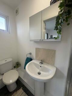 Bright modern bathroom with a pedestal sink, mi...