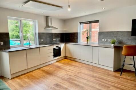 Bright modern kitchen with L-shaped white cabin...