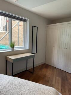 Bright, modern bedroom with a large window, bui...