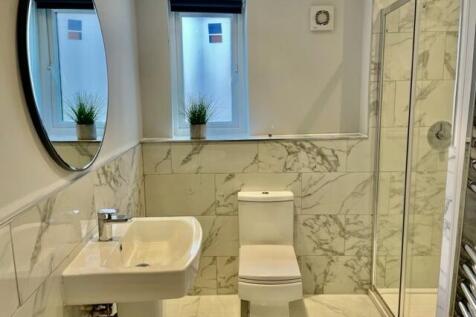 Bright, modern bathroom with marble-effect tile...