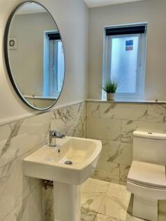 Bright, modern bathroom with marble-effect tili...