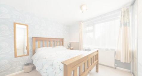A bright and inviting double bedroom with a coz...