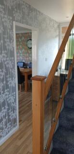 A bright and tidy hallway leading to inviting s...