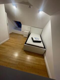 A neat and modern single bedroom with a white b...