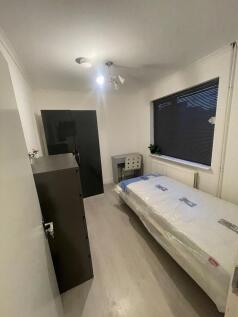 A well-lit single bedroom with a comfortable si...