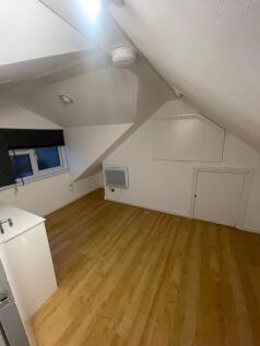 A cozy bedroom featuring sloped ceilings and wo...