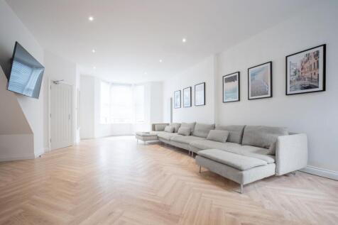 Bright, contemporary living room with large bay...