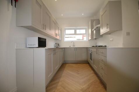 Modern galley kitchen with light grey cabinetry...