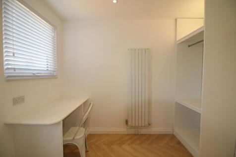 Bright, minimalist single bedroom with a built-...