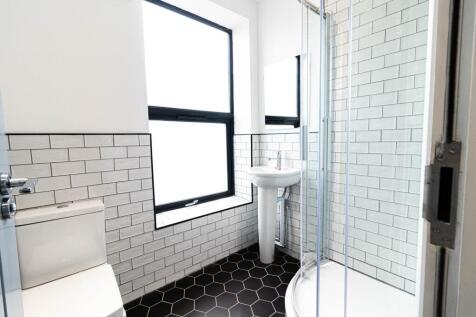 Bright, modern bathroom with a tiled shower enc...