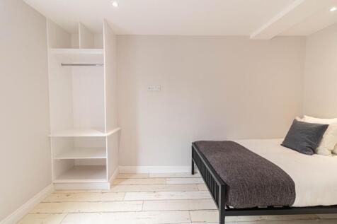 Bright, freshly painted bedroom with built-in o...