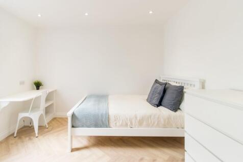 Bright, minimalist double bedroom with a white ...