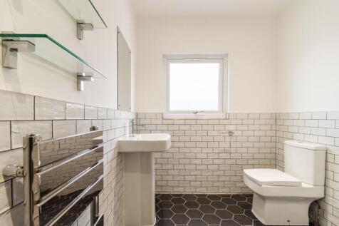 Bright, modern bathroom with crisp white tiles,...