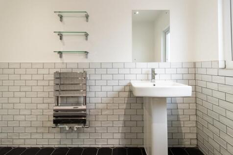 Bright, modern bathroom with a pedestal sink, s...
