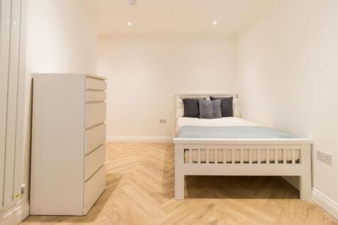 Neat, modern furnished bedroom with a white sla...