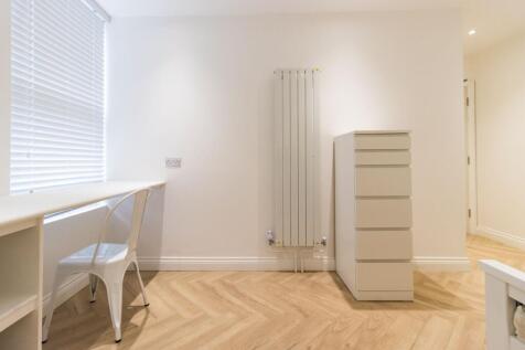 Bright, minimalist single bedroom with a built-...