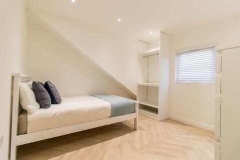 Bright, modern single bedroom with clean white ...
