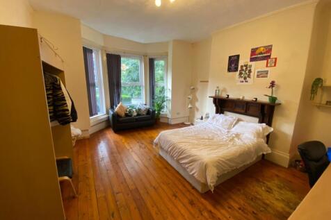 Bright double bedroom with wooden floors, a com...