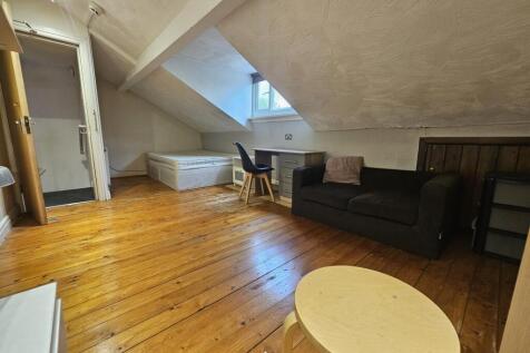 Bright attic-style living space with polished w...