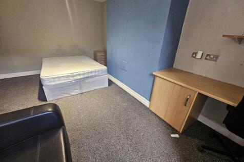 Bright, simply furnished bedroom with a double ...