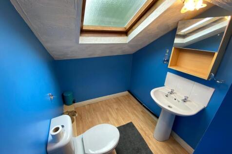 Bright, modern bathroom with bold blue walls, w...