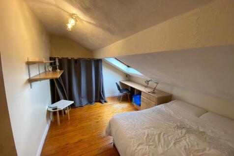 Cozy attic bedroom with a sloped ceiling, woode...