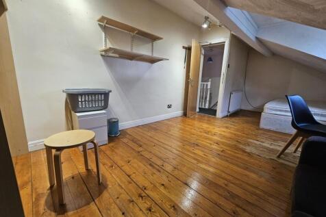 Bright attic bedroom with polished wooden floor...