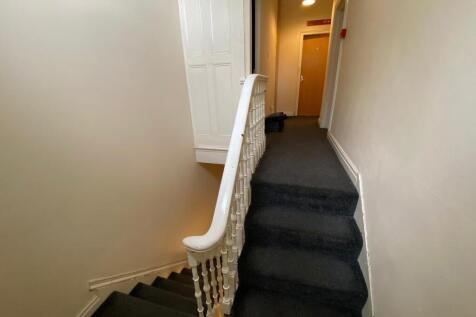 Carpeted stairway and upper landing with white ...