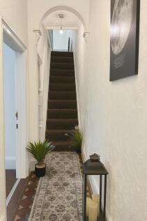 A well-maintained staircase with a cozy runner ...