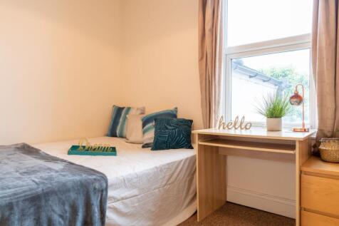 Bright, neatly styled single bedroom with a com...