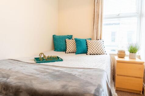 Bright, neatly styled bedroom with a comfortabl...