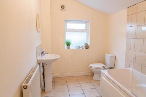 Bright, well-maintained bathroom with a bathtub...