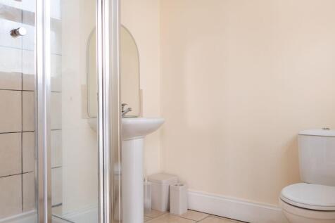 Bright, tidy bathroom with a corner shower, ped...