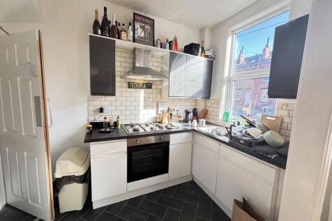 A bright, well-lit kitchen with modern cabinetr...