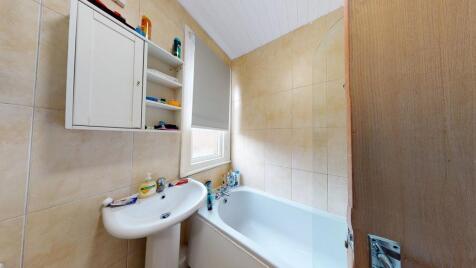 Bright and clean bathroom with a bathtub, sink,...