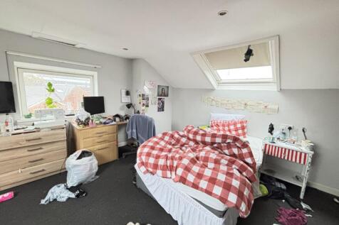 A cozy bedroom with a large window letting in n...