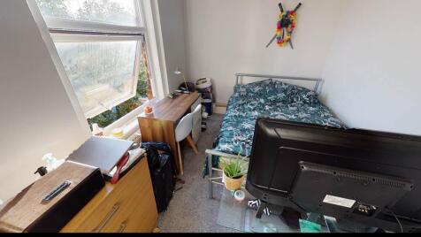 A cozy student bedroom featuring a single bed, ...