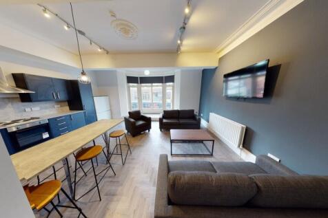 A spacious and modern living room featuring com...